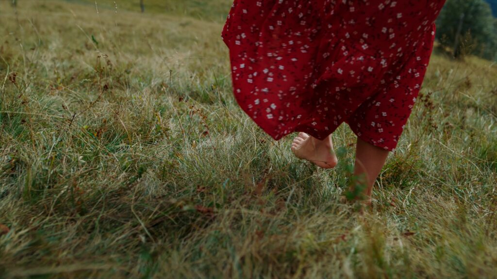 Barefoot girl walking grass cloudy day closeup. Lady feet making steps on meadow